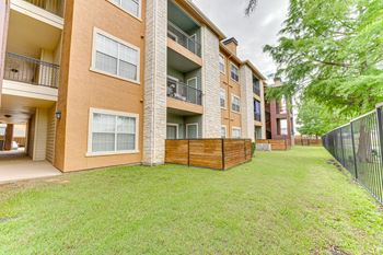 Apartment complex with a green lawn in front at Limestone Ranch Apartments, Lewisville